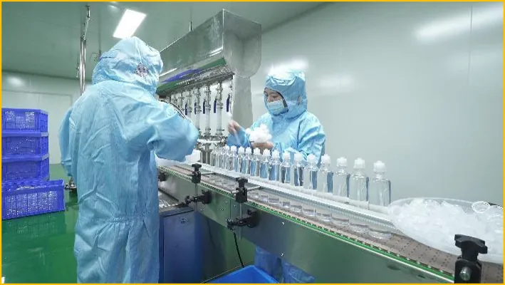 Operators in cleanroom suits at a bottle filling line